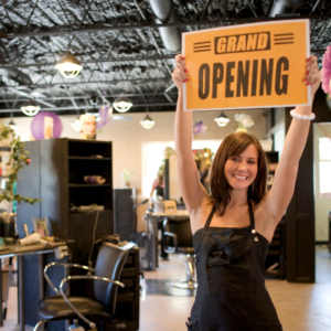 Event Marketing image shoes an attractive woman holding up a sign that reads: Grand Opening